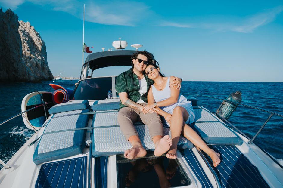A professional sport fishing boat cruises on the vast, deep cobalt blue water off the coast of Cabo San Lucas under a clear sky.