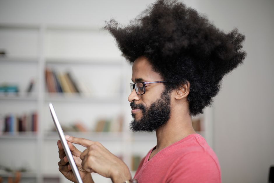 A homeowner sits in a bright, modern living room, confidently using a tablet to manage their property sale, symbolizing the ease and savings of real estate disruptors.